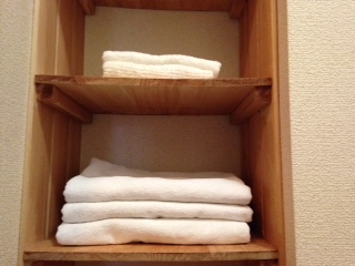 白い今治タオルが並んだ洗面所の棚画像